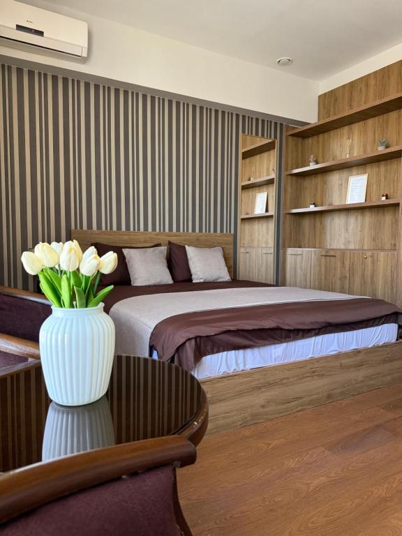a bedroom with a bed and a vase with flowers in it at Apartment in Yerevan City Center Republic Square Self Check-In in Yerevan