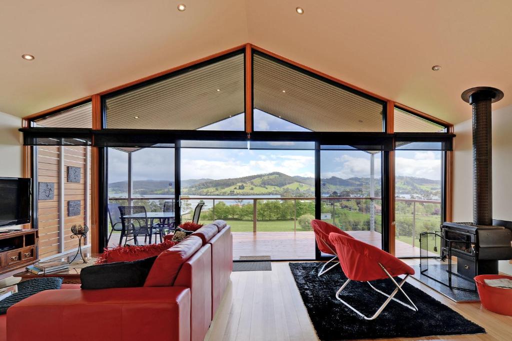 a living room with a red couch and a large window at Moon River in Gardners Bay