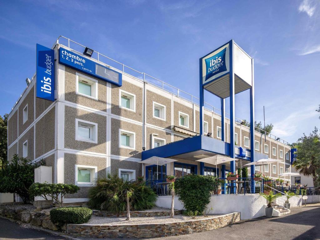 a hotel with blue signs on the side of a building at ibis budget Antibes Sophia Antipolis in Vallauris