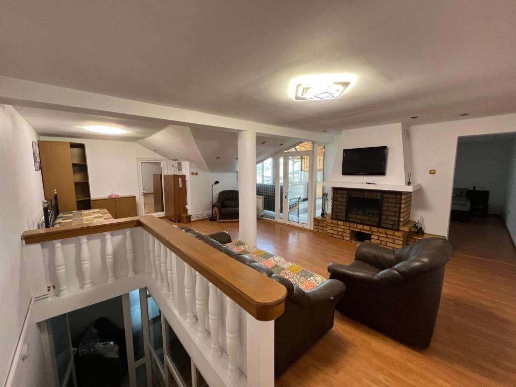 Una sala de estar con un sofá y una chimenea. en Casa Raicu, en Ploieşti
