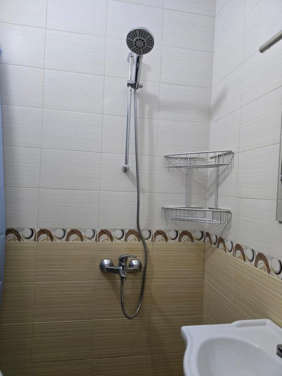 a shower in a bathroom with a sink at Апартамент Мони in Veliko Tŭrnovo