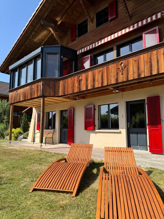 two wooden benches sitting in front of a building at Chalet Zytrösli in Sigriswil