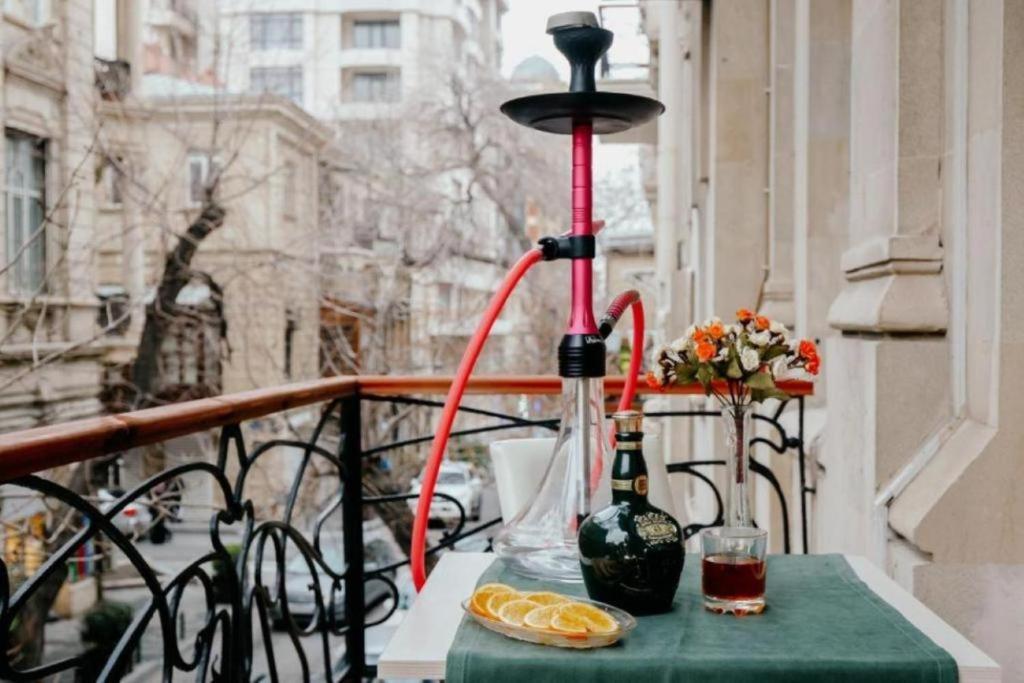 a table with two bottles and a lamp on a balcony at Nizami City Inn Hotel Baku in Baku