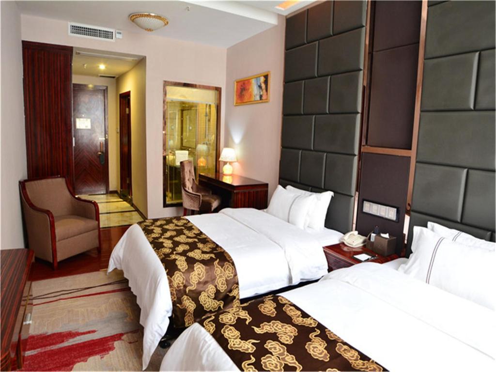 Pokój hotelowy z 2 łóżkami i krzesłem w obiekcie Lavande Hotel Wuhan Railway Station w mieście Wuhan
