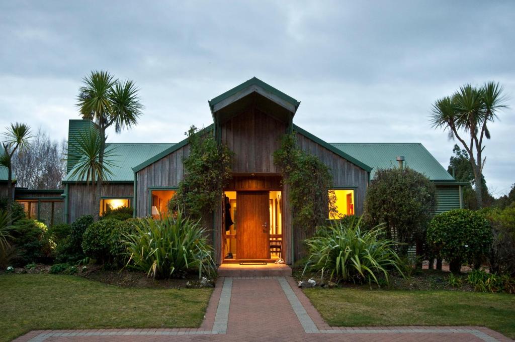 a house with a wooden door in a yard at Whakaipo Lodge in Taupo