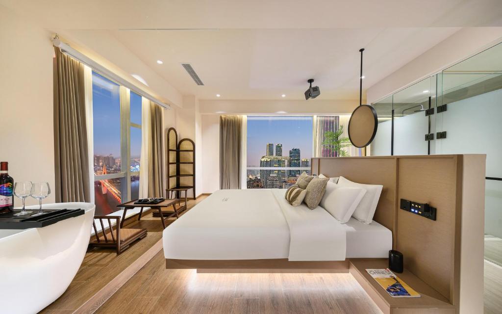 a bedroom with a large white bed and a large window at Liberation Monument Riverside HoteL in Nan'an