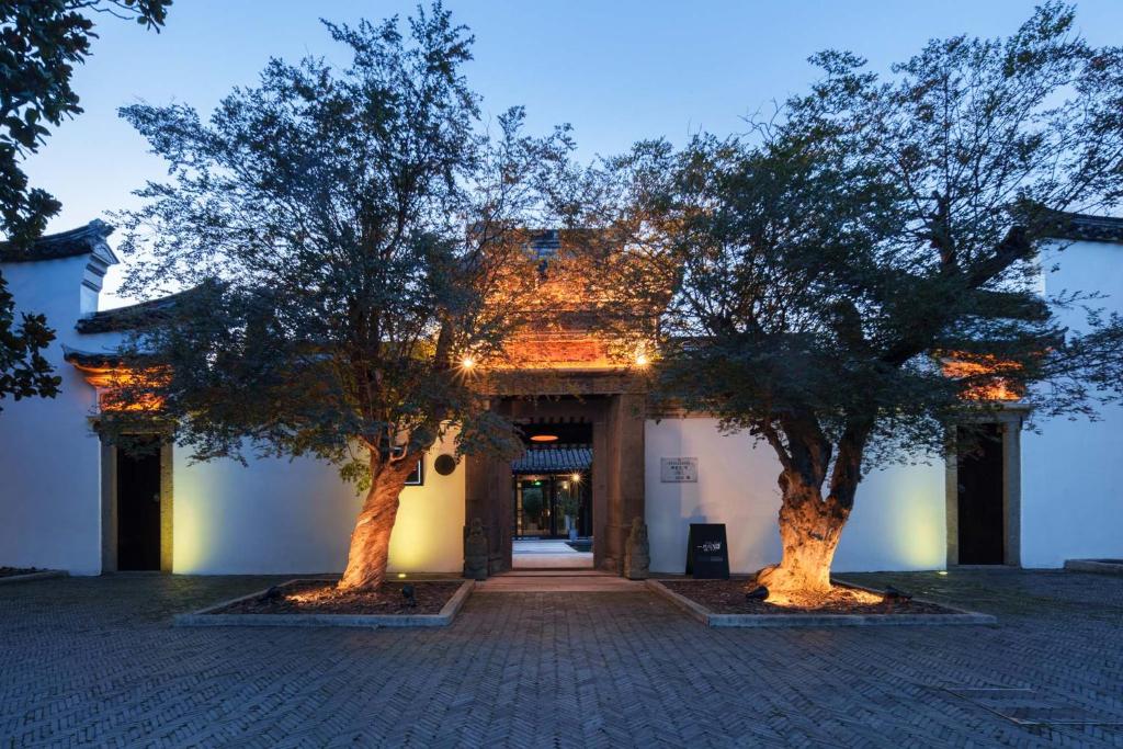 two trees sitting in front of a building at 芯宿-上海陶家宅 in Shanghai