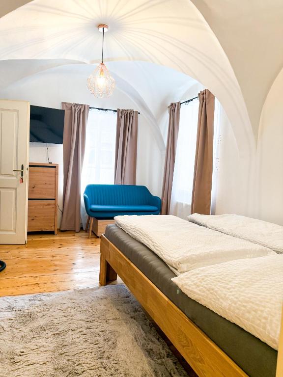 a bedroom with a bed and a blue chair at Danube Holiday Homes Studio - Top 2 in Krems an der Donau