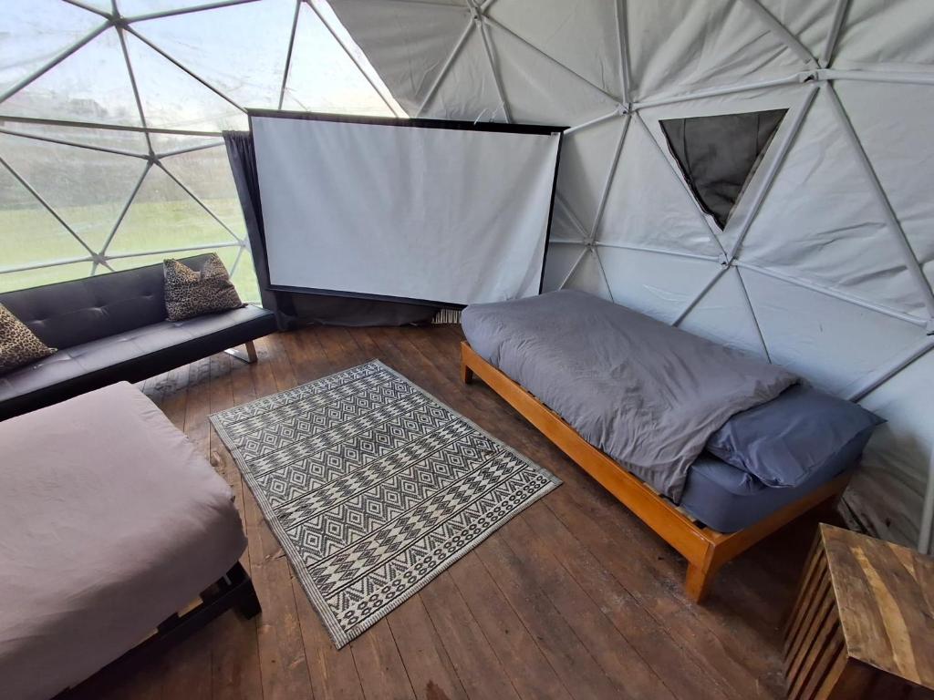 a room with a bed and a couch in a yurt at Secret Heated Dome, Hot Tub,Firepit Projector in Lincoln in Lincoln