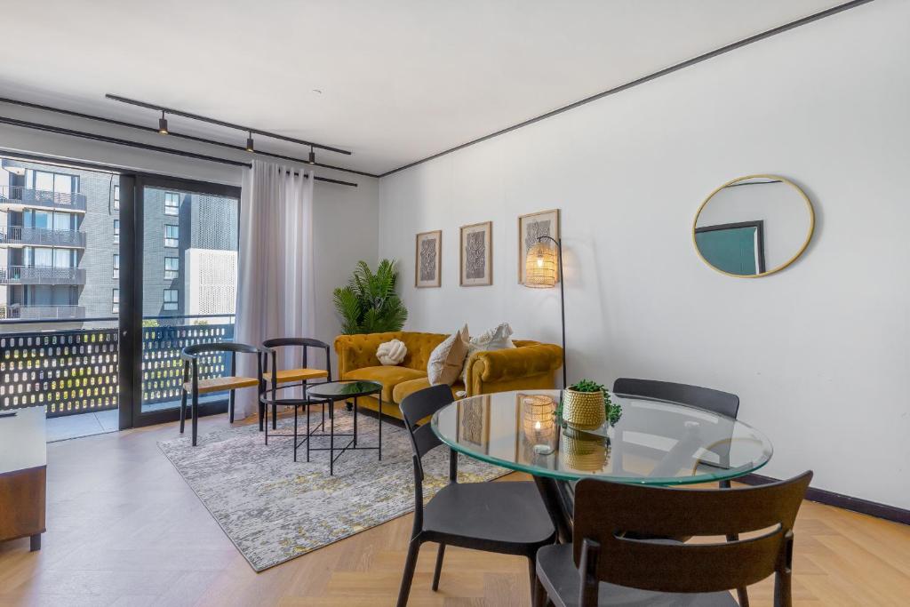 un salon avec une table en verre et des chaises dans l'établissement Nine Palms - Century City Luxury Apartment, au Cap