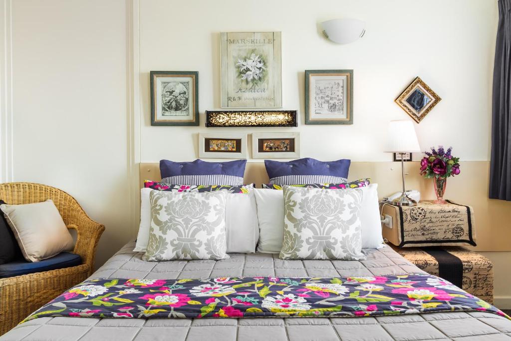 a bedroom with a bed with colorful pillows at Airport Riverview Motel in Brisbane