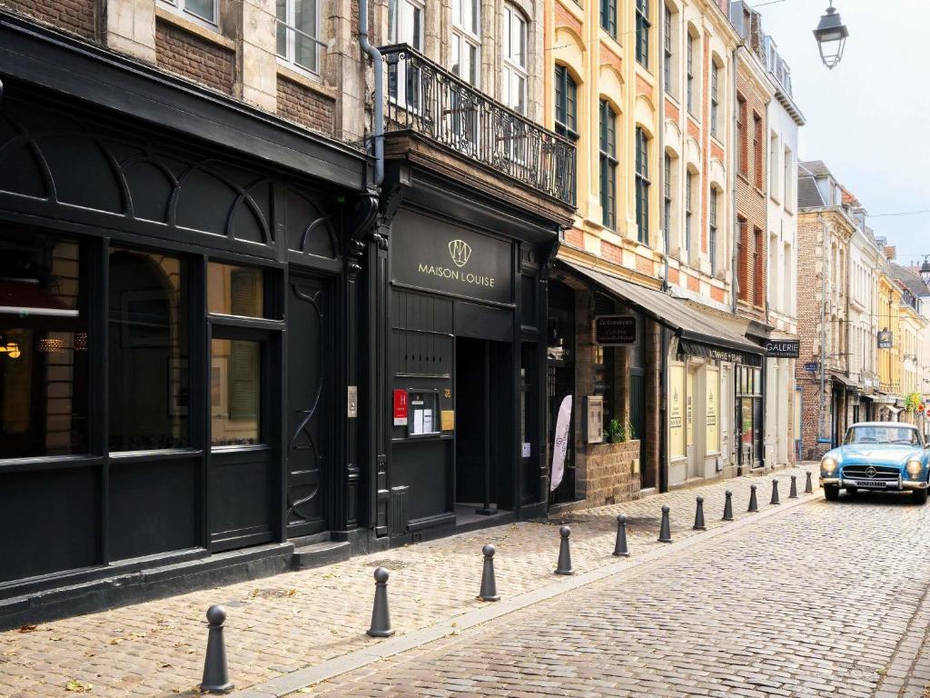 a car driving down a street with buildings at Hotel Maison Louise Lille Centre - Handwritten Collection in Lille