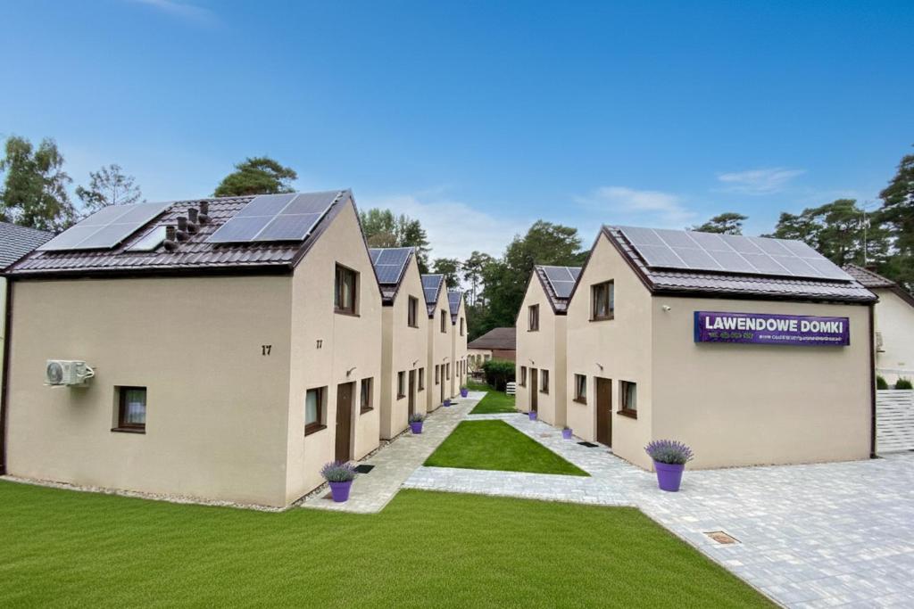 una fila de casas con paneles solares en sus tejados en Lawendowe Domki i Apartamenty w Pobierowie, en Pobierowo
