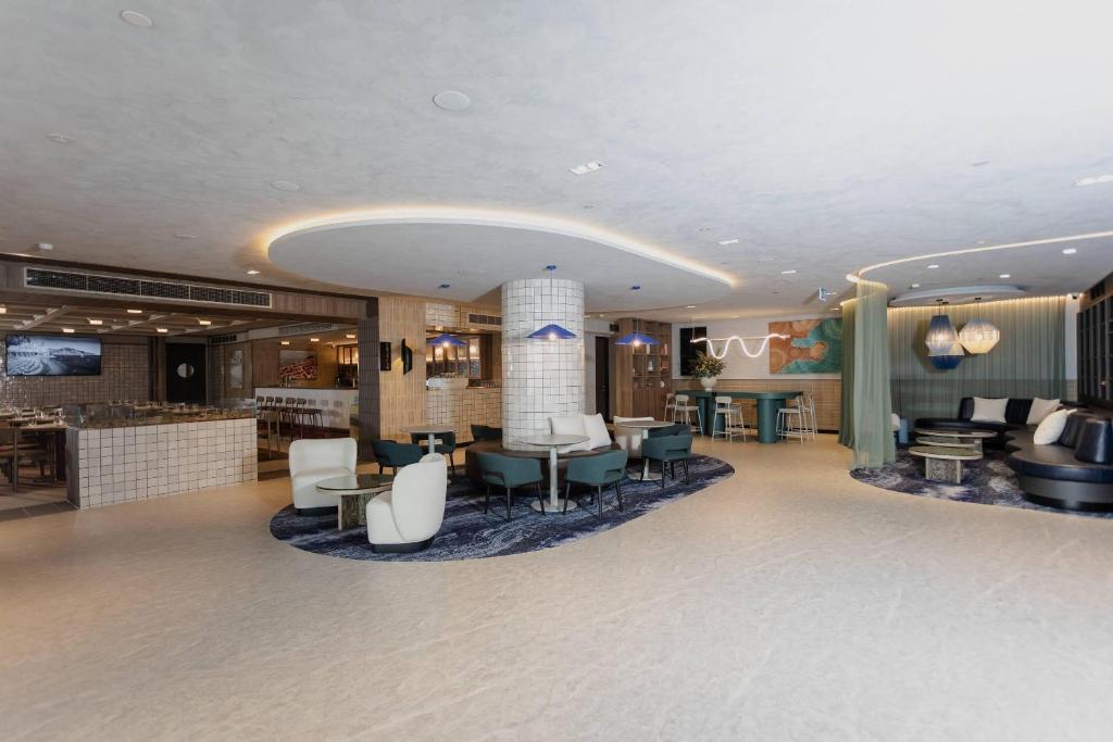 a lobby of a hotel with chairs and tables at Bayside Geelong Hotel & Apartments, an Ascend Collection Hotel in Geelong