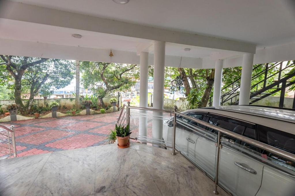 an empty house with a porch with a pool and trees at Altinho Heritage Castle Homestay in Ettumānūr