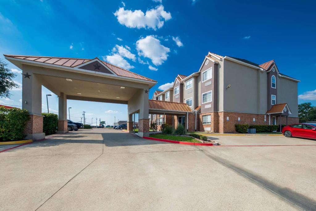 a large building with a car parked in a parking lot at Quality Inn & Suites North Mesquite I-30 in Mesquite