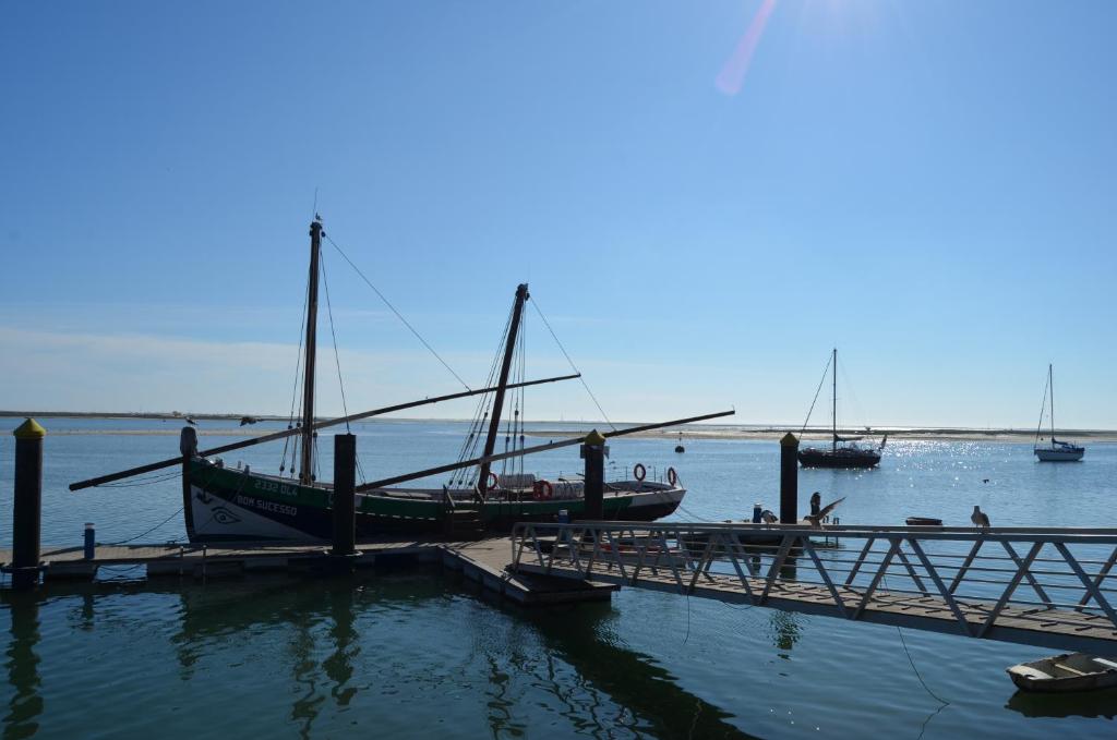 a boat is docked at a dock in the water at BJB Apartamento in Olhão