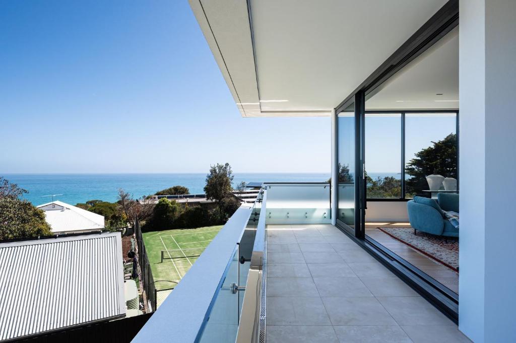 a view of the ocean from the balcony of a house at The Crest - Elevated Luxe with Pool & Spa in Mount Martha