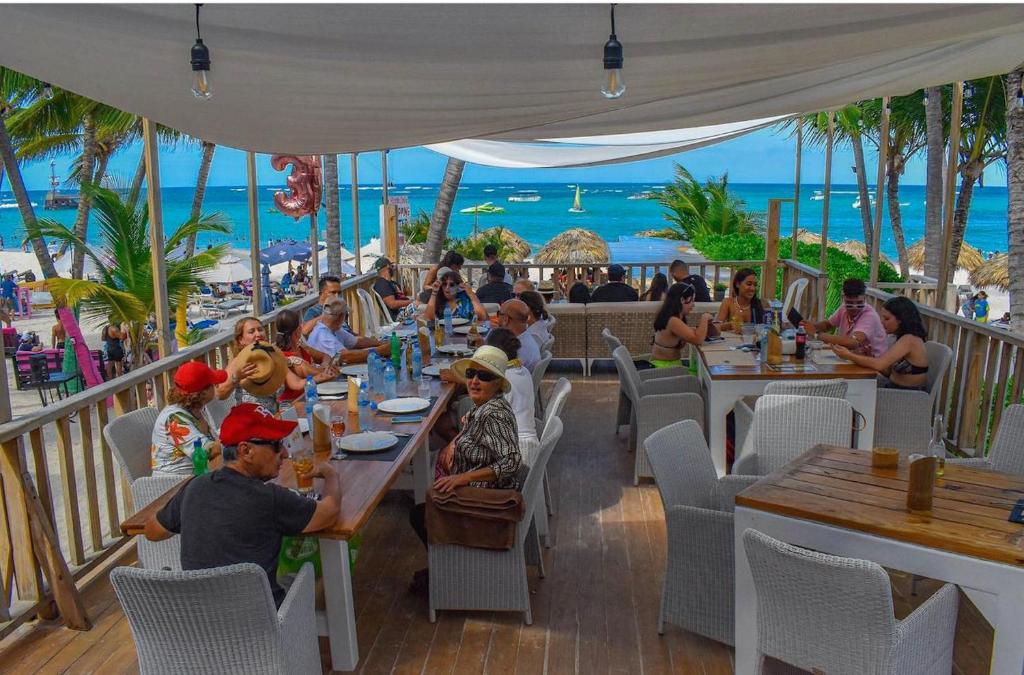 a group of people eating at a restaurant on the beach at Condo 1bdr 1bth on the beach in Punta Cana