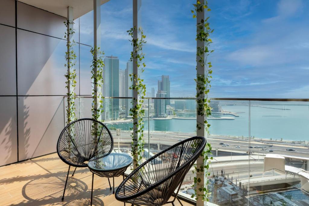 a balcony with two chairs and a view of the city at Comfortable 1 Bedroom with Balcony Vista 1 in Abu Dhabi