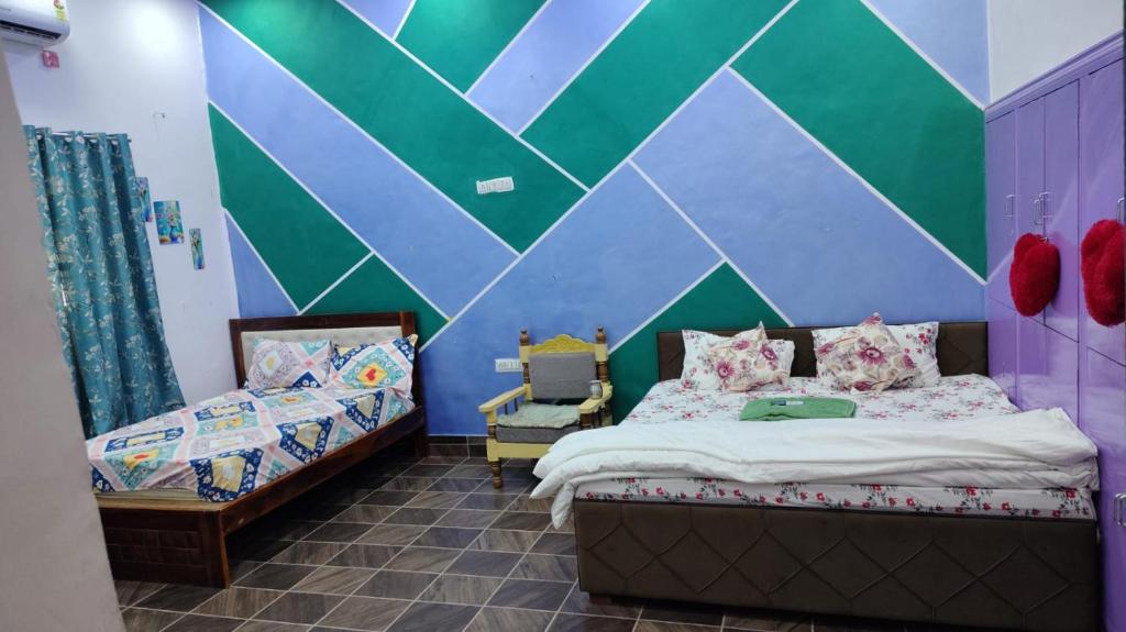 une chambre avec deux lits jumeaux et un mur orné d'un motif géométrique dans l'établissement hotel the saffron leaf, à Jodhpur