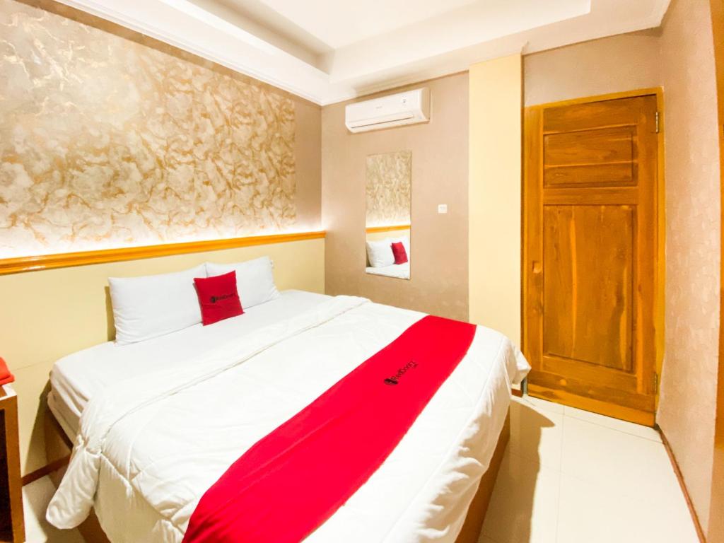 プロボリンゴにあるRedDoorz at The Canal Homestay Probolinggoのベッドルーム(赤い毛布付きの白い大型ベッド1台付)