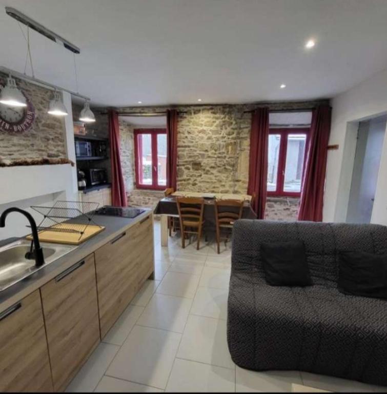 a kitchen with a sink and a dining room at Appartement rdc maison Ed Den in Tauves
