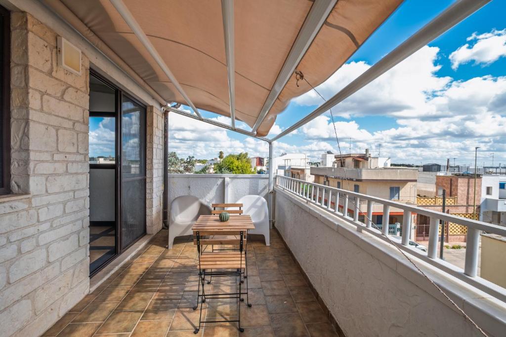 a balcony with a table and chairs on a building at Golden Bay Lux House in Torre Lapillo
