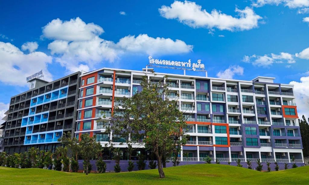an apartment building with a sign on top of it at The Par Phuket Hotel in Ban Thung Thong