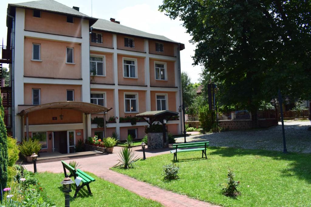 a building with two green benches in front of it at Hotel Tintyava 2 in Varshets
