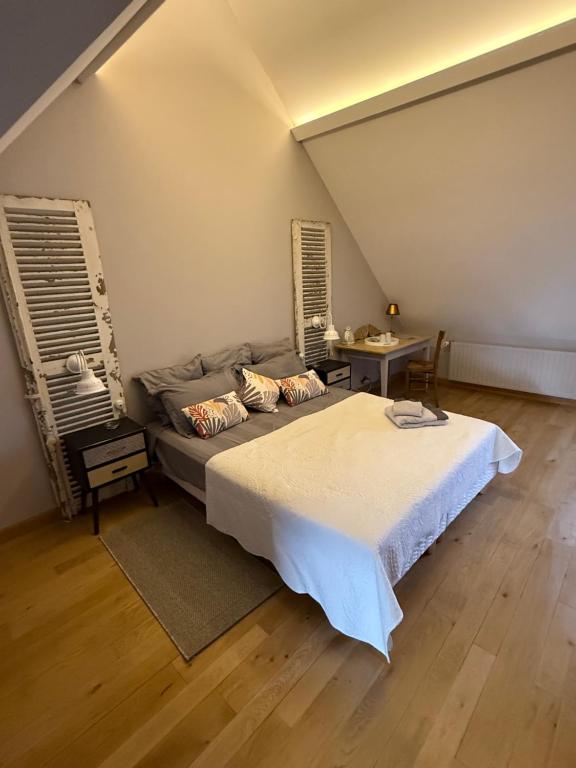 a bedroom with a large bed and a table at Chambre Solognote in Saint-Pryvé-Saint-Mesmin