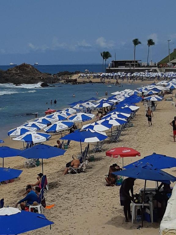 a bunch of blue and white umbrellas on a beach at Hospedagem Porto Barra in Salvador
