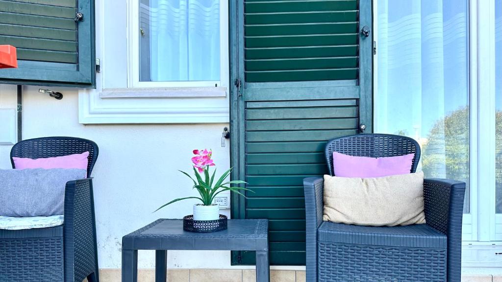 two wicker chairs and a table on a patio at Trilocale con giardino, posto auto e wi-fi - P034 in Porto Recanati
