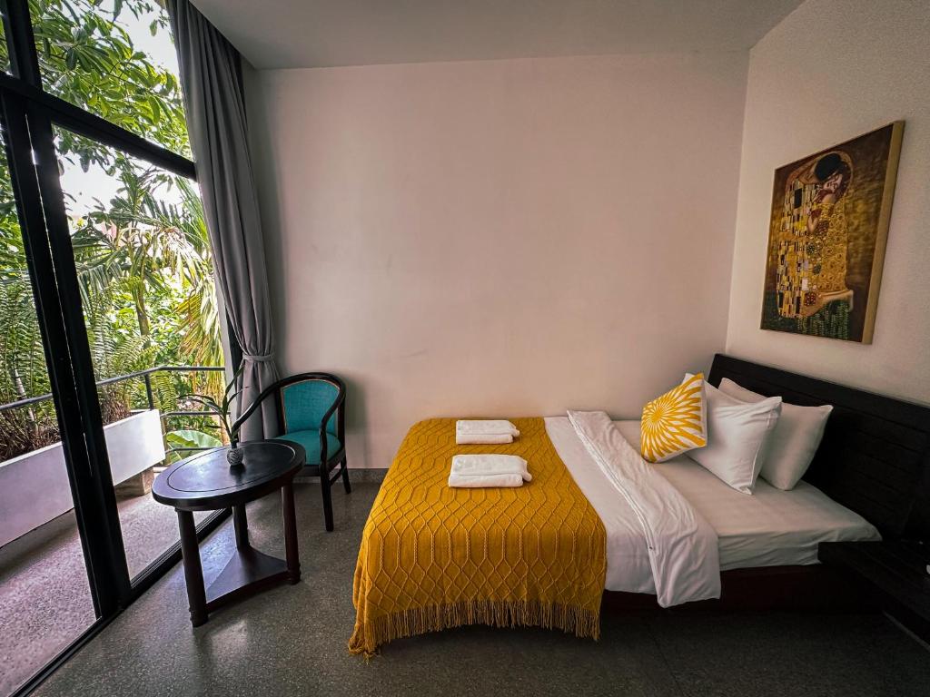 Un dormitorio con una cama y una mesa y una ventana. en Tropical Garden House, en Siem Reap