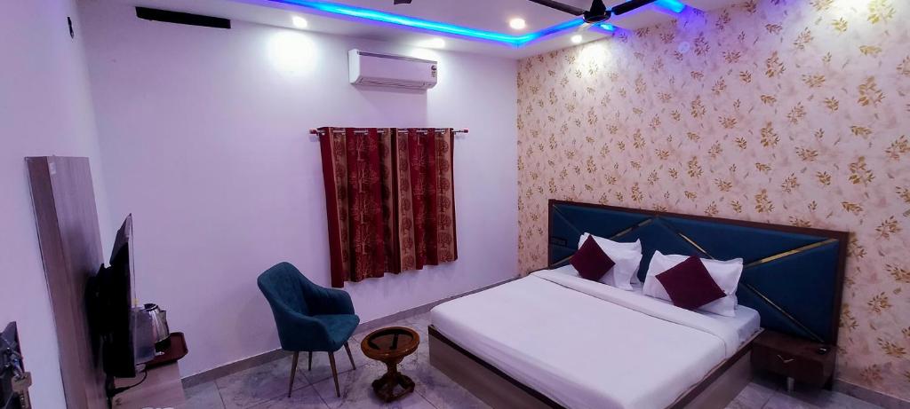 a bedroom with a bed and a chair in a room at Kashi Satya Luxury Stay in Varanasi