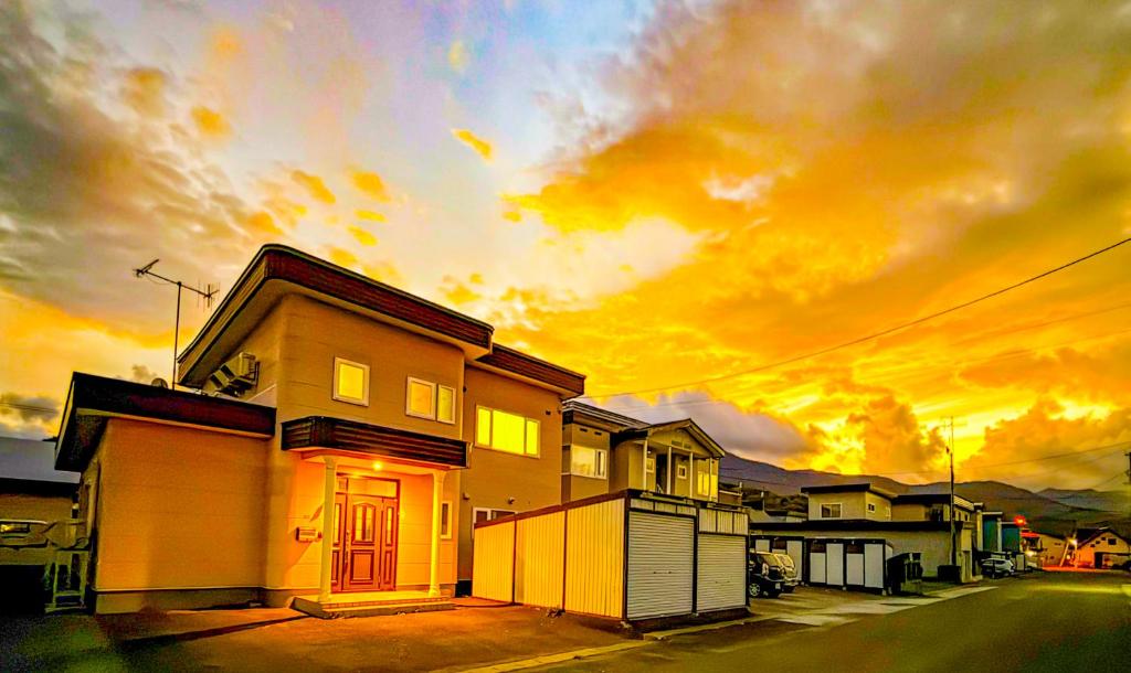 a house with a cloudy sky in the background at Tokinoma Furano in Furano