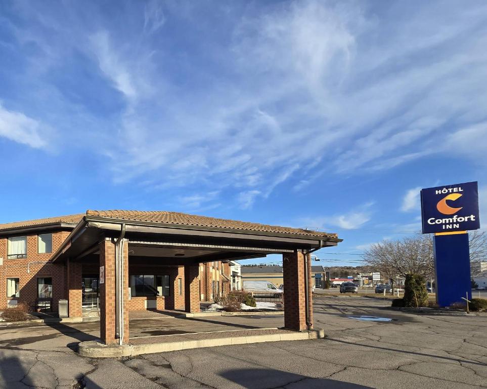 a building with a sign in a parking lot at Comfort Inn Riviere-du-Loup in Rivière-du-Loup