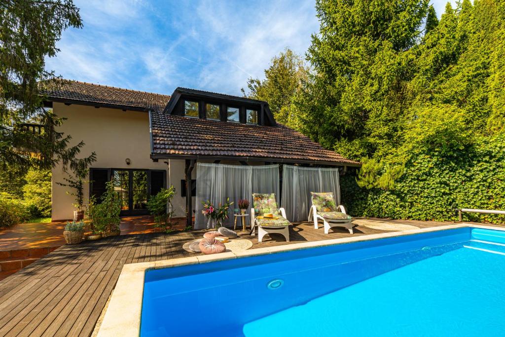 a house with a swimming pool in front of a house at Villa Art Vita - Private Pool, Sauna & River Access in Donji Zvečaj
