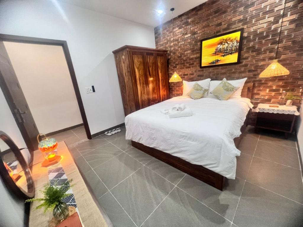 a bedroom with a large bed and a mirror at Betel Hoi An Homestay in Cam Thanh
