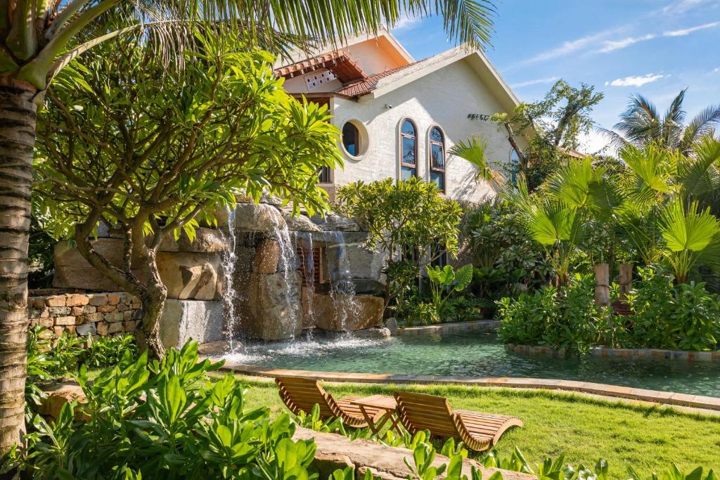 Una casa con cascada y piscina con sillas. en Sun Village, en Tuy Hoa