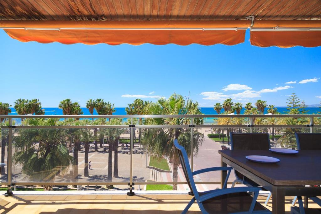Un balcón con mesa y sillas y palmeras. en TOUS 1 - Only Families, en Salou