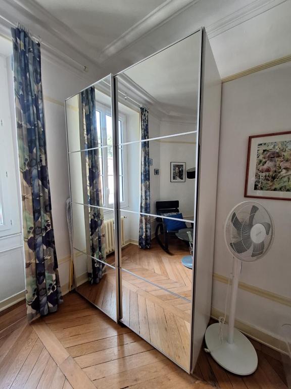 un grand miroir dans une pièce avec un ventilateur dans l'établissement Appartement tout équipé - Le Beau Site, à Aix-les-Bains