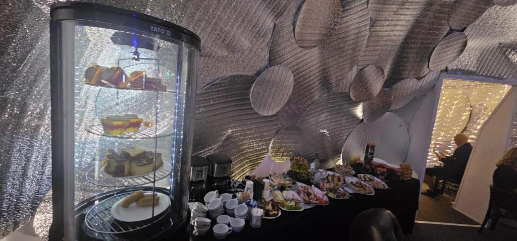 a table with plates of food in a glass case at MILITARY Guest Inn in Drawsko Pomorskie