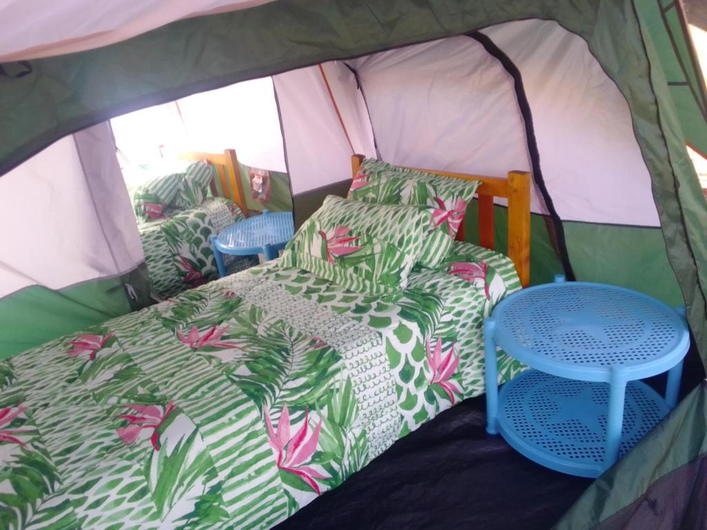 a bed and a table in a tent at Ndege Mingi Bush Camp - Laikipia in Nanyuki