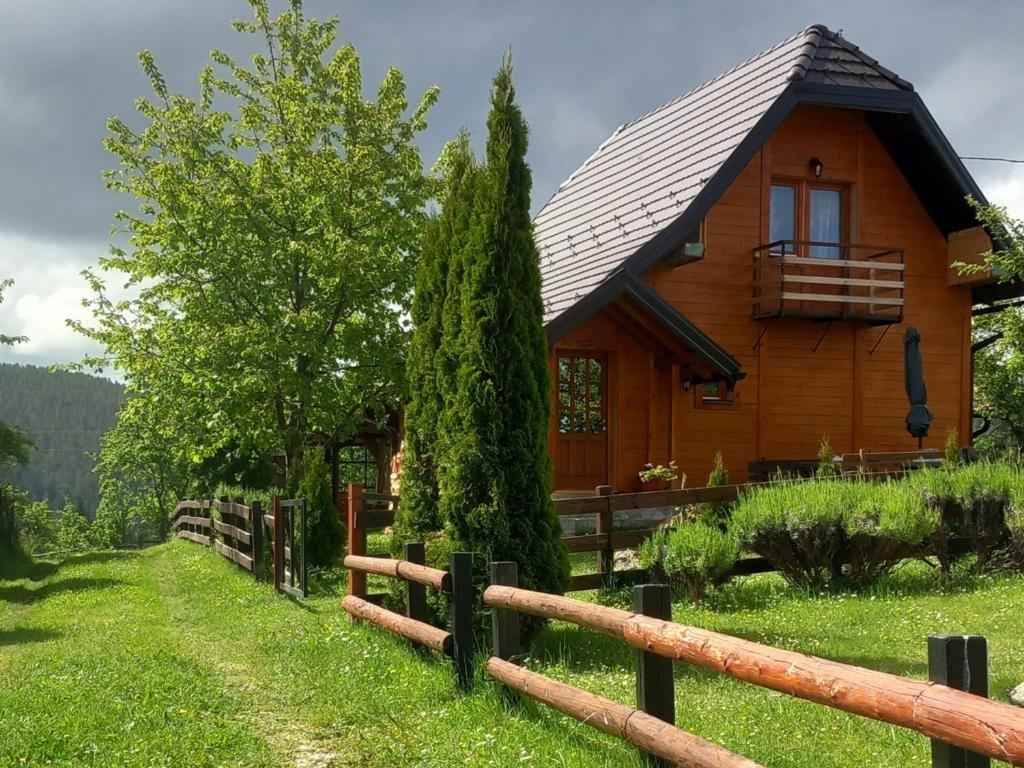a log cabin with a fence in front of it at Brvnare Na Brdu in Šljivovica