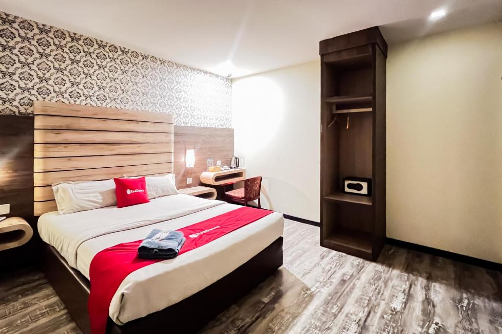 a hotel room with a large bed and a desk at RedDoorz Plus at Paragon Nagoya Hotel Batam in Nagoya