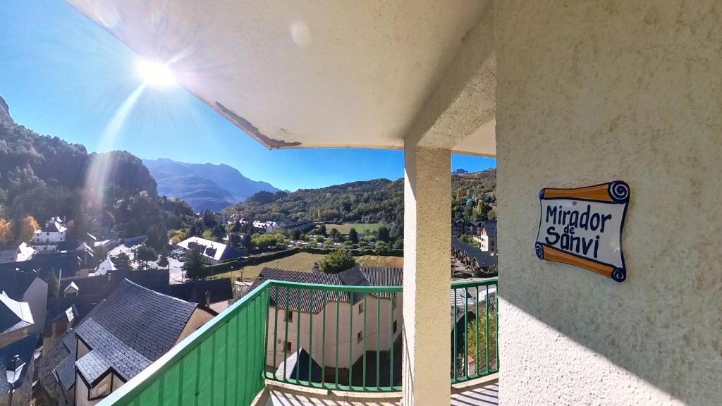 a balcony with a view of a town and mountains at Mirador de Sanvi - tucasaenlospirineos in Sallent de Gállego