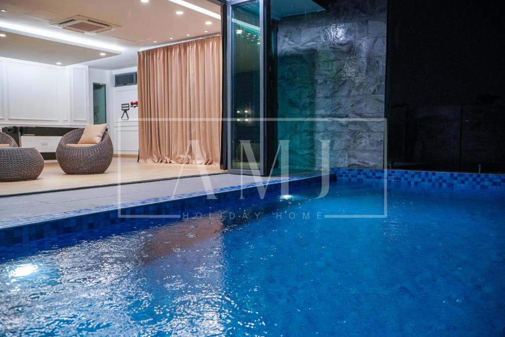普崇Cyberjaya - Puchong Luxury Private Swimming Pool Villa with BBQ - Corner lot up to 20 Guests的蓝色房子中的游泳池