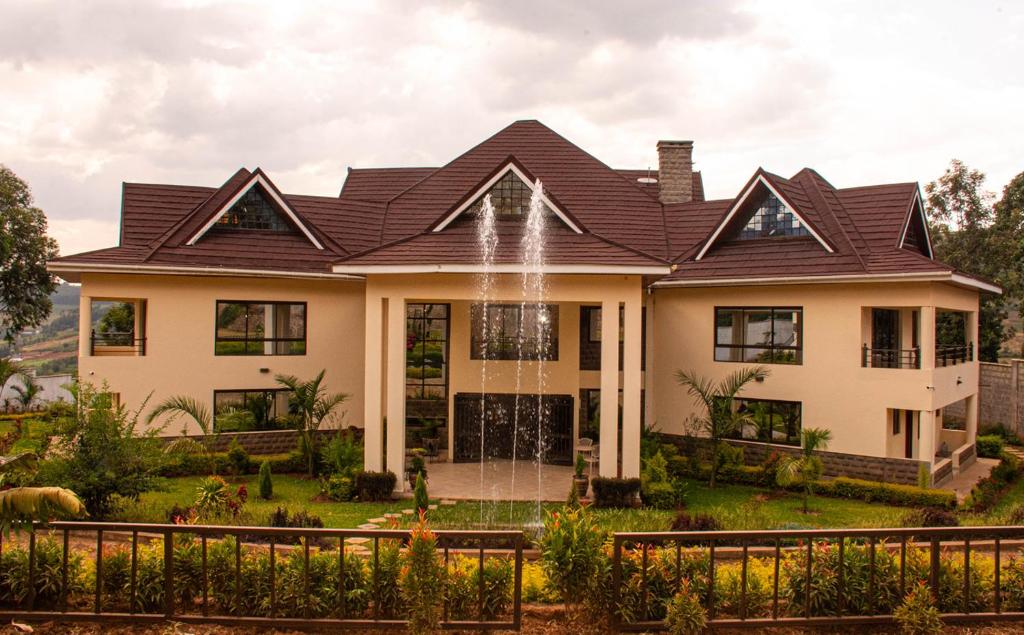 a house with a fountain in front of it at Ekom Nest in Musereita