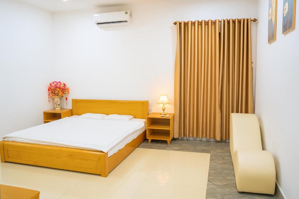 un dormitorio con una cama y una silla en Avina Hotel Đắk Nông, 